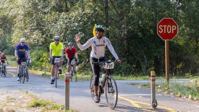 RSVP rider waves after passing a stop sign on the Centennial Trail