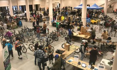 Customers peruse bikes and gear in a large exhibition hall.